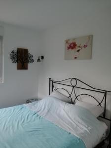 Dormitorio blanco con cama con marco negro en Le petit Loir, gîte sur la Loire à vélo 
