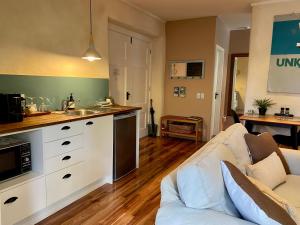 a living room with a couch and a kitchen at Woodstock Suite in Nelson