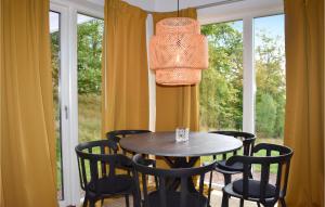 comedor con mesa, sillas y ventana en Lovely Home In stra Snnarslv With Kitchen, en Östra Sönnarslöv