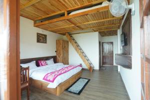 - une chambre avec un lit et un plafond en bois dans l'établissement Lap Of Himalayas Resort, à Kausani