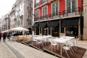 un grupo de mesas y sillas en una calle de la ciudad en Hotel Lis Baixa en Lisboa