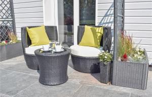three wicker chairs and a table on a patio at Gorgeous Home In St-Martin-Aux-Buneaux in Saint-Martin-aux-Buneaux