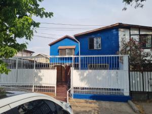 a blue house behind a white fence at Apartamento Interior 2do Piso Casa, 026 Quilicura in Santiago