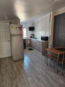 Apartamento Interior 2do Piso Casa, 026 Quilicura في سانتياغو: مطبخ فيه ثلاجة وطاولة