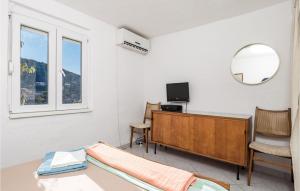 1 dormitorio con escritorio, TV y espejo en Amazing Home In Klada With House Sea View, en Donja Klada
