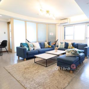 a living room with blue couches and a table at NK BLD3F Sapporo 3LDK 3BR 1 floor 1 room in Minami-jūichijō