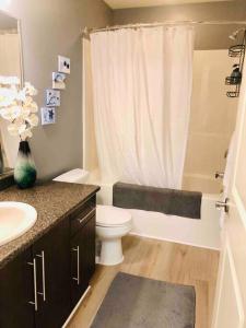 a bathroom with a toilet and a sink and a shower at Olympic Views - Cozy Modern 2Br Suite in Victoria