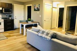 a living room with a couch and a kitchen at Olympic Views - Cozy Modern 2Br Suite in Victoria