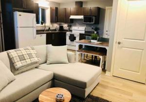a living room with a couch and a kitchen at Olympic Views - Cozy Modern 2Br Suite in Victoria