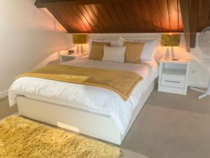 sypialnia z dużym białym łóżkiem z 2 stolikami nocnymi w obiekcie Robins Nest w mieście Edwinstowe