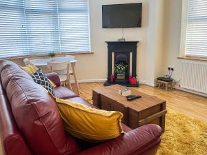a living room with a couch and a fireplace at Robins Nest in Edwinstowe