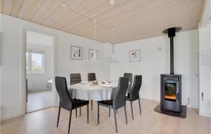 EgernsundにあるAwesome Home In Egernsund With 2 Bedrooms And Wifiのダイニングルーム(テーブル、椅子、薪ストーブ付)