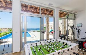 a living room with a foosball table in front of a pool at Beautiful Home In Trsteno With Wifi in Trsteno