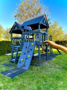 a blue play structure with a slide in the grass at Hotel Graffit in Świebodzin