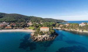 an island with a house in the middle of the water at Maggiolino al mare in Cavo