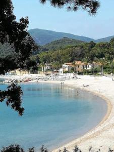 a beach with people swimming in the water at Maggiolino al mare in Cavo +8 photos