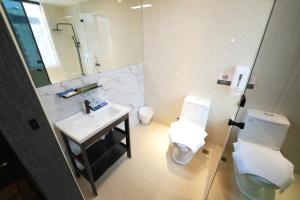 La salle de bains est pourvue d'un lavabo, de toilettes et d'un miroir. dans l'établissement Puremeworld Hotel, à Taipei