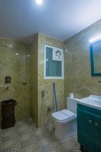 een badkamer met een toilet en een wastafel bij Mukteshwar Treat Resort in Mukteswar