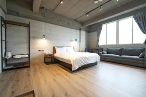 1 dormitorio con 1 cama y 1 sofá en Puremeworld Hotel en Taipéi