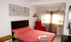 1 dormitorio con cama roja y silla roja en Plaja Cabanyal, en Valencia