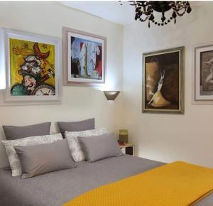 una camera da letto con un letto e dipinti alle pareti di Casa Christine a Taormina