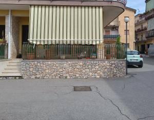 a building with a fence and a building with awning at Casa Azzurra in Giardini Naxos