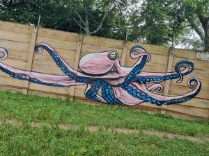 een schilderij van een octopus op een houten hek bij Kaia Homestead in Sodwana Bay