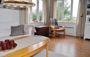 een woonkamer met een bank, stoelen en ramen bij Amazing Home In Kristinehamn With Wifi in Kristinehamn