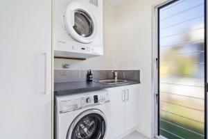 a laundry room with a washer and dryer and a sink at Allure in Point Lookout