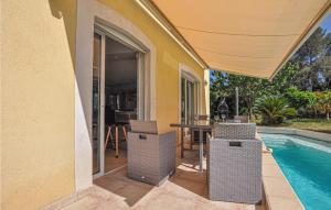 a patio with chairs and a table next to a swimming pool at Lovely Home In Saint Raphael in Saint-Raphaël