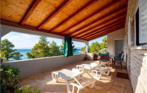 a patio with white chairs and a wooden ceiling at Gorgeous Home In Tankaraca With Wifi in Vela Luka