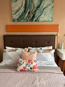Bett mit orangefarbenem Kopfteil und Kissen darauf in der Unterkunft Seawind Cozy 2Br Modern Scandinivian in Davao City + 20 Fotos