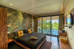 a bedroom with a large bed and a large window at The Hosteller Goa, Arpora in Arpora