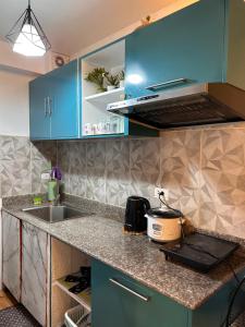 eine Küche mit blauen Schränken und einer Arbeitsplatte in der Unterkunft Seawind Cozy 2Br Modern Scandinivian in Davao City