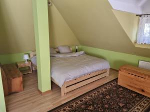 Dormitorio pequeño con cama en el ático en Domek nad rzeką, en Joniec