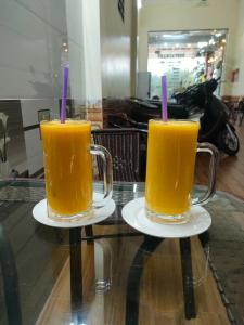 two glasses of orange juice sitting on top of a table at Train Station Backpackers Hostel in Ninh Binh