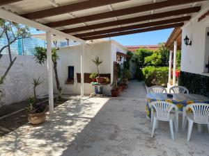 un patio con mesa y sillas bajo una pérgola en Alexia’s Beach House, en Káto Ássos