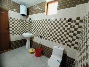 La salle de bains est pourvue de toilettes et d'un lavabo. dans l'établissement Lap Of Himalayas Resort, à Kausani