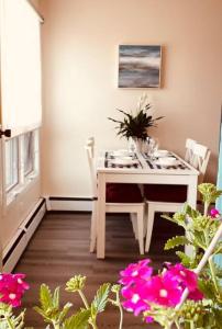 a white table and chairs in a room with flowers at unit #303 Mountain view 1BR in Canmore DownTown in Canmore