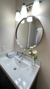 a bathroom sink with a mirror and a vase with flowers at unit #303 Mountain view 1BR in Canmore DownTown in Canmore