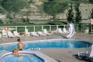 un hombre sentado en una piscina en un resort en Paradise Canyon Golf Resort, Signature Condo 382 en Lethbridge