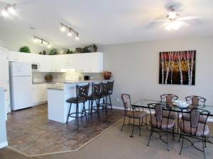 una cucina con tavolo e sedie in una stanza di Paradise Canyon Golf Resort, Signature Condo 382 a Lethbridge