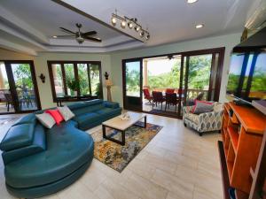 a living room with a blue couch and a table at Casa Lynda - 3 Bedrooms in West Bay