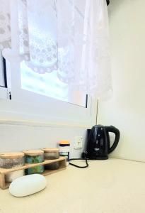 eine Küchentheke mit einer Kaffeekanne und einem Fenster in der Unterkunft דירת נופש במרכז טבריה in Tiberias