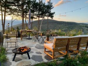 um pátio com uma fogueira, um banco e uma mesa em Minds & Mountains Eco Lodge em La Molina