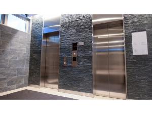 una fila de puertas de ascensor en un edificio en ＹＯＵ ＳＴＹＬＥ ＨＯＴＥＬ ＨＡＫＡＴＡ - Vacation STAY 16012v en Fukuoka