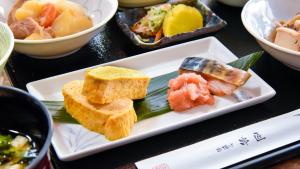 ＹＯＵ ＳＴＹＬＥ ＨＯＴＥＬ ＨＡＫＡＴＡ - Vacation STAY 16012v في فوكوكا: طبق من الطعام مع السوشي على طاولة