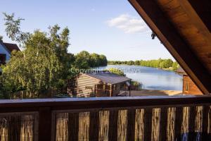 a view from the deck of a cabin on a lake at Stunning Log Cabin With A Pool Table For Hire In Norfolk, Sleeps 8 Ref 34045al in King's Lynn