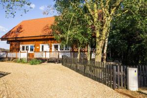 a wooden fence in front of a house at Stunning Log Cabin With A Pool Table For Hire In Norfolk, Sleeps 8 Ref 34045al in Kings Lynn