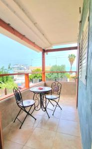 eine Terrasse mit 2 Stühlen und einem Tisch auf dem Balkon in der Unterkunft דירת נופש במרכז טבריה in Tiberias